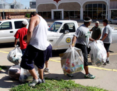 ENMU coaches and players load up trash collected near downtown Portales